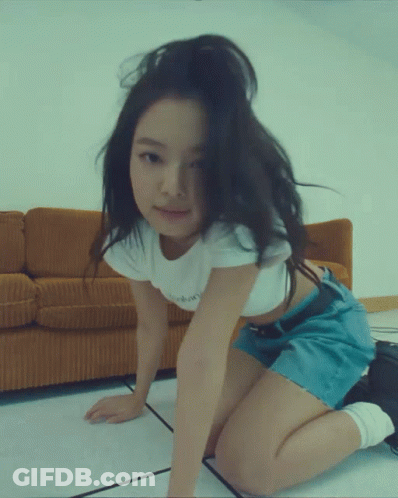 A Woman In A White Crop Top And Blue Shorts Is Kneeling Down GIF