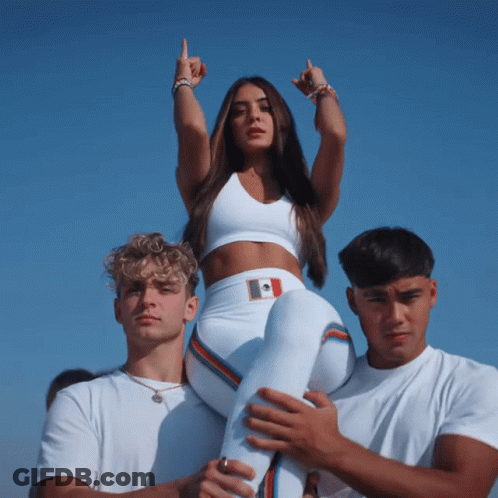 A Woman In A White Crop Top Is Being Carried On The Shoulders Of Two Men GIF