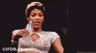 A Woman In A White Crop Top Is Holding A Bottle Of Water In Her Hand . GIF