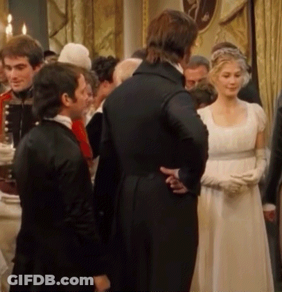 A Woman In A White Dress And Gloves Stands In A Crowd Of People GIF