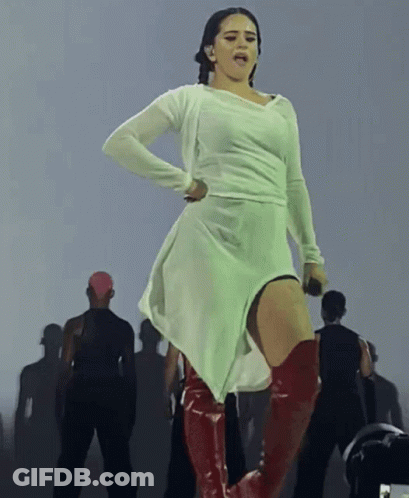 A Woman In A White Dress And Red Boots Stands On Stage GIF