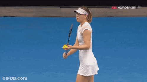 A Woman In A White Dress And Visor Is Playing Tennis On A Blue Court . GIF