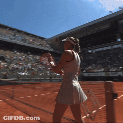 A Woman In A White Dress Holds A Tennis Racquet On A Tennis Court GIF