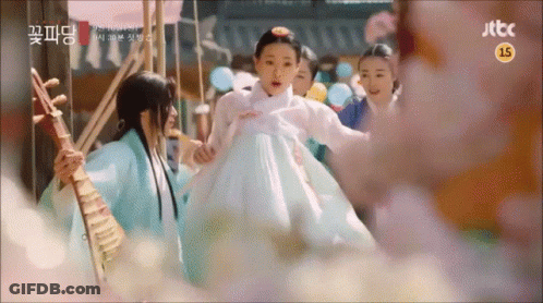 A Woman In A White Dress Is Being Held By A Man Playing A Musical Instrument .. GIF
