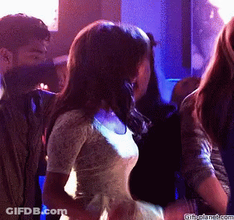 A Woman In A White Dress Is Dancing In A Club With Gifsplanet.com Written On The Bottom Of The Image GIF
