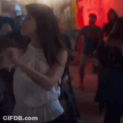 Woman In White Dress Dancing On Crowded Floor GIF