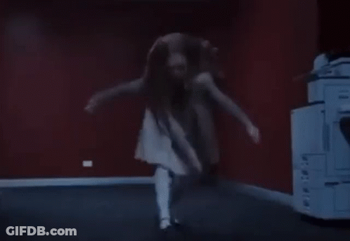 A Woman In A White Dress Is Dancing In A Dark Room In Front Of A Printer . GIF
