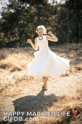 A Woman In A White Dress Is Dancing In A Field With The Text Happy Married Life GIF