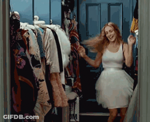 A Woman In A White Dress Is Dancing In Front Of A Closet With A Sign That Says Om GIF