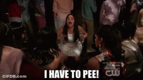 A Woman In A White Dress Is Dancing In Front Of A Crowd And Says I Have To Pee ! GIF