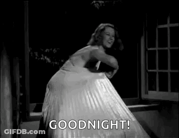 A Woman In A White Dress Is Dancing In Front Of A Window And Says `` Goodnight '' . GIF