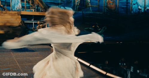 A Woman In A White Dress Is Dancing On A Stage In Front Of A Sign That Says ' Pepsi ' GIF