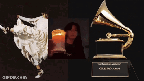 A Woman In A White Dress Is Holding A Candle And A Grammy Award GIF