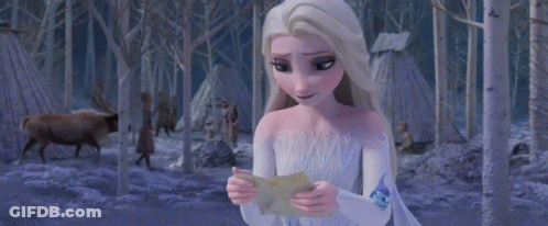 A Woman In A White Dress Is Holding A Piece Of Paper That Says ' I Love You ' On It GIF