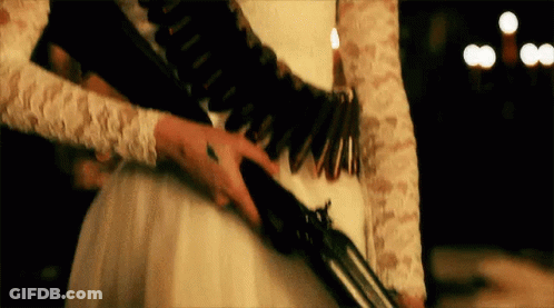 A Woman In A White Dress Is Holding A Shotgun . GIF