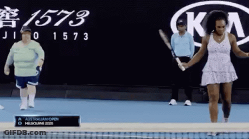 A Woman In A White Dress Is Holding A Tennis Racquet In Front Of A Kia Logo GIF