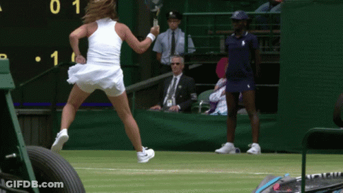 A Woman In A White Dress Is Holding A Tennis Racquet In Front Of A Scoreboard With The Number 1 On It GIF