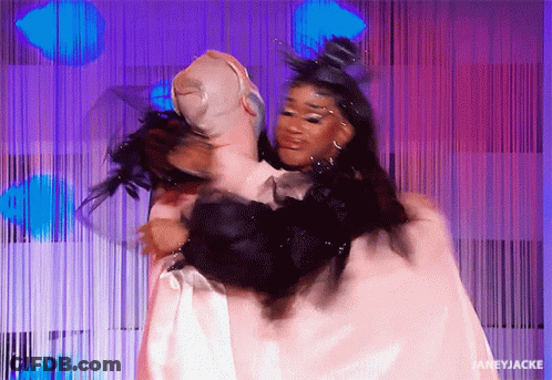 A Woman In A White Dress Is Hugging Another Woman In A Black Fur Coat . GIF