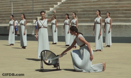 A Woman In A White Dress Is Kneeling In Front Of A Group Of Women In White Dresses GIF