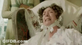 A Woman In A White Dress Is Laying In A Hospital Bed And Crying . GIF