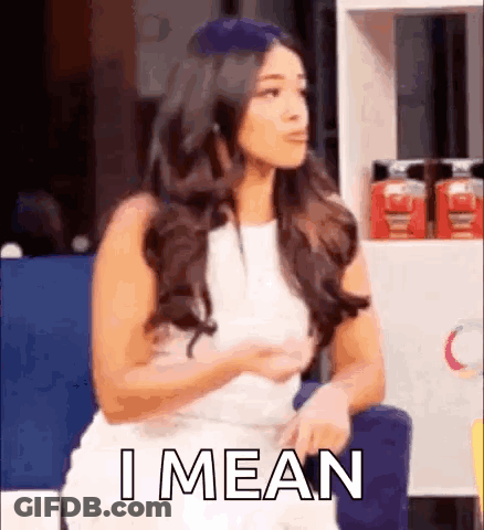 A Woman In A White Dress Is Sitting In A Chair With Her Hands On Her Hips And Says `` I Mean '' . GIF