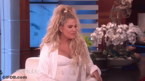 A Woman In A White Dress Is Sitting On A Couch On A Television Show . GIF