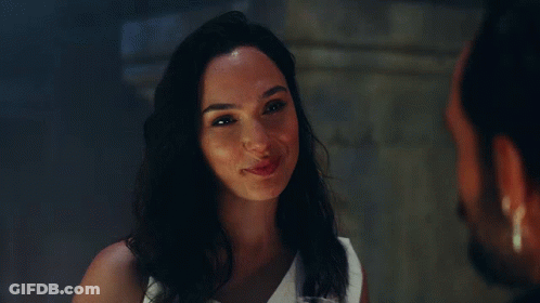 A Woman In A White Dress Is Smiling At A Man GIF