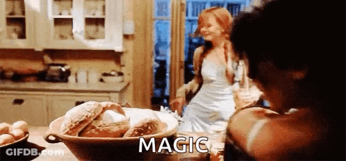A Woman In A White Dress Is Standing In A Kitchen Next To A Bowl Of Bread And A Bowl Of Eggs . GIF
