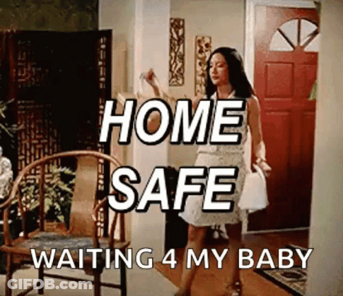 A Woman In A White Dress Is Standing In A Living Room With The Words Home Safe Waiting 4 My Baby Written Above Her GIF