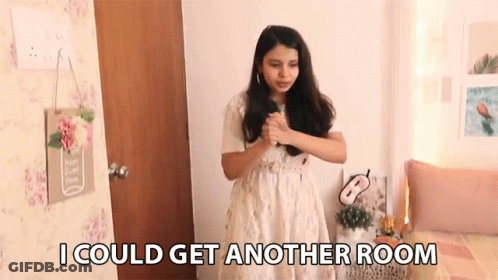 A Woman In A White Dress Is Standing In A Room With The Words " I Could Get Another Room " Above Her GIF