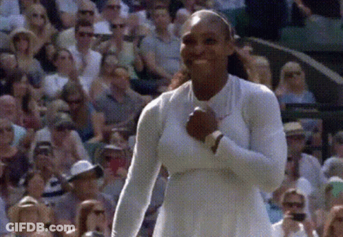 A Woman In A White Dress Is Standing In Front Of A Crowd Of People GIF