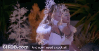A Woman In A White Dress Is Standing In Front Of A Snowy Forest And Says `` And Now I Need A Cocktail '' . GIF