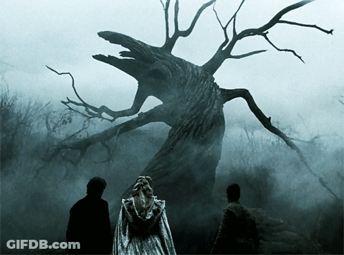 A Woman In A White Dress Is Standing In Front Of A Tree GIF