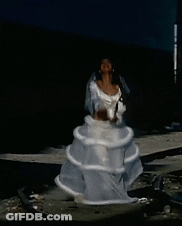 A Woman In A White Dress Is Standing In The Water With Her Arms In The Air GIF