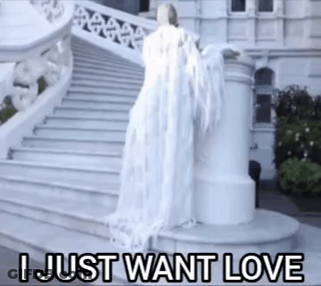 A Woman In A White Dress Is Standing On A Set Of Stairs With The Words I Just Want Love Above Her . GIF