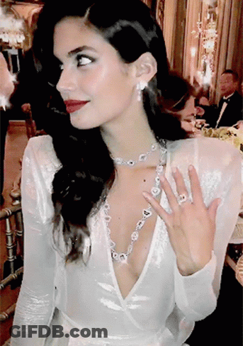Woman In White Dress Wearing Diamond Necklace And Earrings GIF
