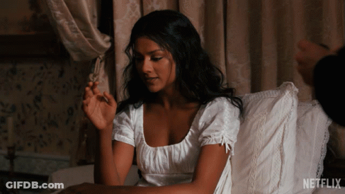 A Woman In A White Dress Sits On A Bed With A Netflix Logo On The Bottom GIF
