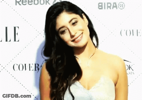 A Woman In A White Dress Smiles In Front Of Reebok And Bira GIF
