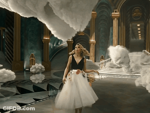 A Woman In A White Dress Stands In A Room With Clouds GIF