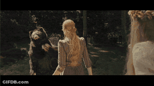 A Woman In A White Dress Stands In Front Of A Large Bear GIF