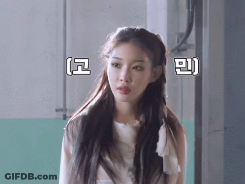 A Woman In A White Dress Stands In Front Of A Wall With Chinese Writing On It GIF