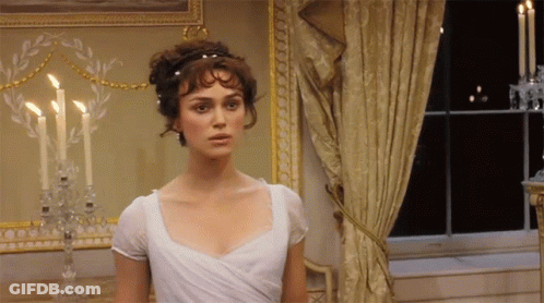 A Woman In A White Dress Stands In Front Of Candles GIF