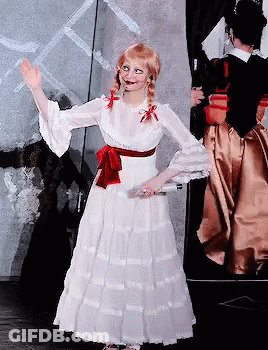A Woman In A White Dress With A Red Bow On Her Waist GIF