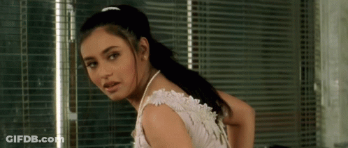 A Woman In A White Dress With Pearls Around Her Neck GIF