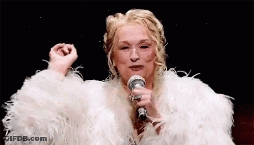 A Woman In A White Fur Coat Is Holding A Microphone . GIF
