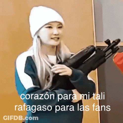 A Woman In A White Hat Is Holding A Gun And The Caption Says " Corazon Para Mi Tali Rafagoso Para Las Fans " GIF
