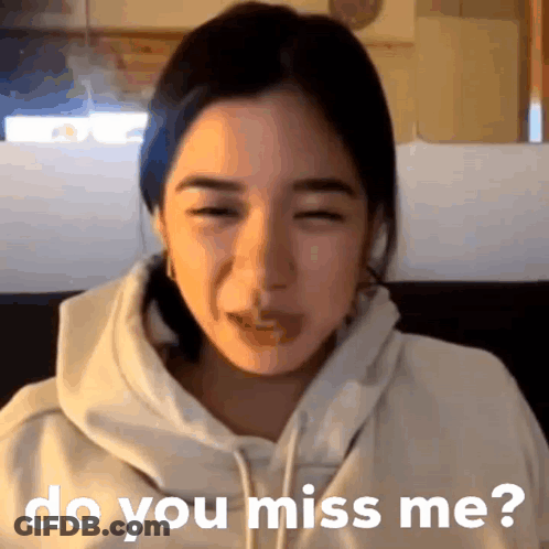A Woman In A White Hoodie Is Sitting On A Couch And Says Do You Miss Me GIF