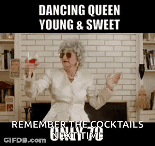 A Woman In A White Jacket Is Holding A Glass Of Red Wine And Dancing GIF