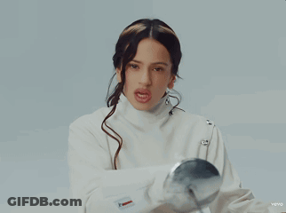A Woman In A White Jacket Is Holding A Silver Ball In Her Hand GIF
