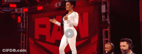 A Woman In A White Jumpsuit Is Standing In Front Of A Raw Sign GIF